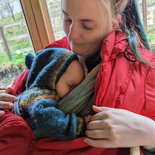 Sarah Labou carrying sleeping child in wrap carrier on her front, Learn Babywearing